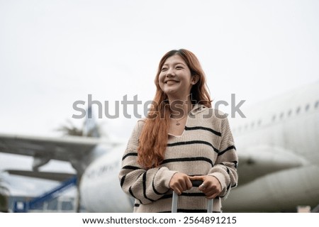 Similar – Image, Stock Photo Female passenger carrying the hand luggage bag, walking the airplane boarding corridor.