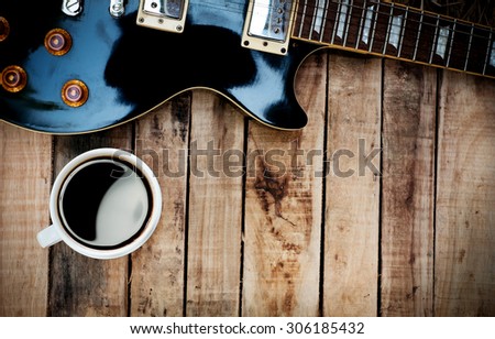 Vintage Electric Guitar and black Coffee on grunge Wood