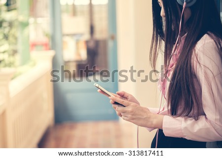 Asian young woman listening with smart phone. vintage effect