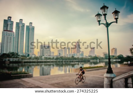 Blurred landscape bangkok city in sunset,city,people biking taken with low speed shutter,motion blur