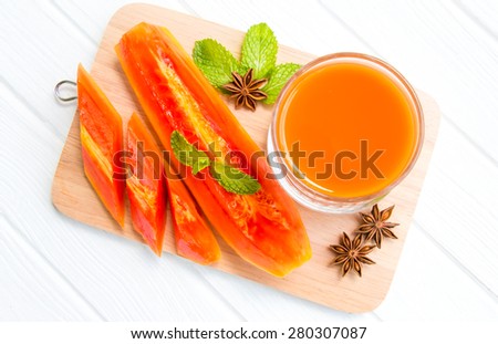 Papaya juice with papaya fruit on wood