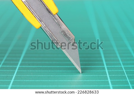 A closeup photo of box cutter with scratches from use , Focused on a sharp blade