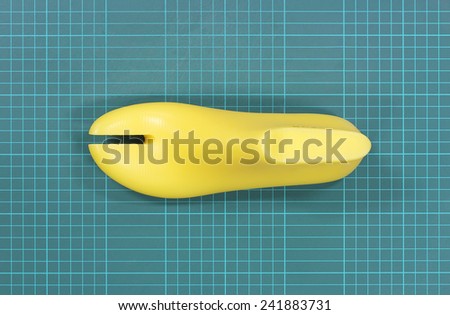Yellow plastic last shoe rough surface from use on green grid pattern background of cutting mat(with clipping path)