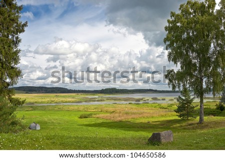 Sorot river in Russia landscape with a boat upside-down and a big stone in front