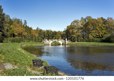 Classical stone bridge over river in the autumn park