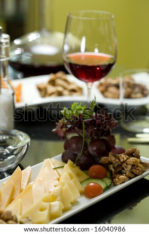 Glass of red wine and assorted cheeses for wine tasting