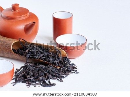 Traditional сhinese teapot made of Yixing clay, oolong 'Da hong pao  大红袍' tea,  known under original chinese name 'Big red robe', wooden spoon and tea cups  on white background , copy space. 商業照片 © 