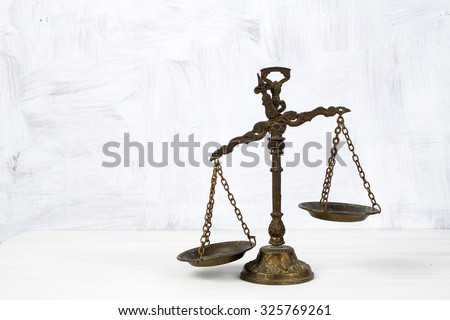 Old scale on a wooden table, justice and knowledge concept
