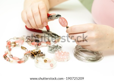 Woman making necklace from colorful gemstone beads