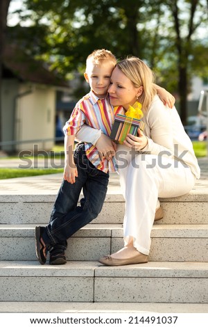 Cheerful young boy with a gift for Mom on Mother\'s Day