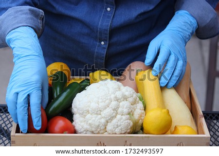 Farmer taking preventive measures while handling locally grown, organic produce by wearing gloves at the Farmer's Market during COVID-19 Foto stock © 