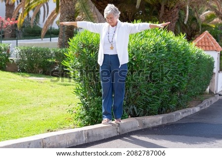 Similar – Image, Stock Photo Woman walking and balancing on a wooden railing at the coast line.