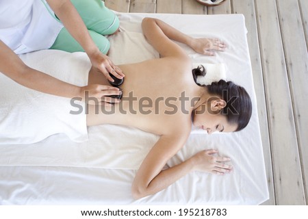 Asian woman getting a massage with hot stones