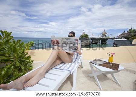 Woman on vacation reading paper, Boracay in Philippines