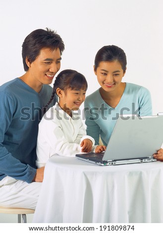 The image of family in Asia looking at laptop