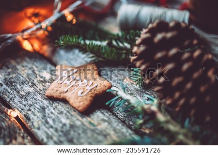 Christmas mood still life on a wooden background with pine cone, Happy holidays gingerbread cookie and lights