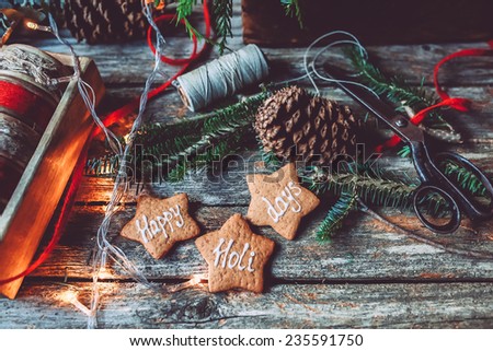 Christmas mood still life on a vintage background with pine cones, gingerbread and lights