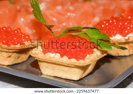 tartlets with red salmon caviar on a light plate with parsley leaf on the table. Stock fotó © 