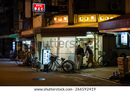 OSAKA, JAPAN - OCTOBER 5, 2014: Men drinking beer in japanese standing pub.