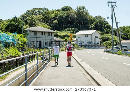 NAOSHIMA, JAPAN - SEPTEMBER 14, 2014: Rear view of two men jogging.