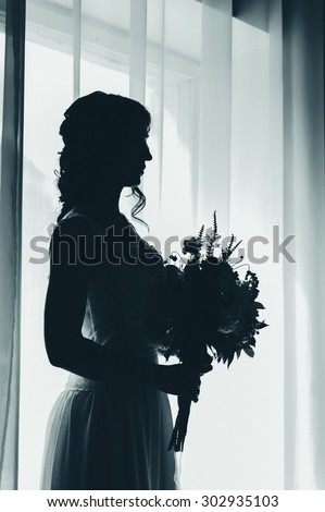 silhouette portrait of the bride with flowers in blue tones