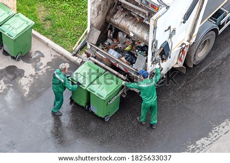 two workers loading mixed domestic waste in waste collection truck