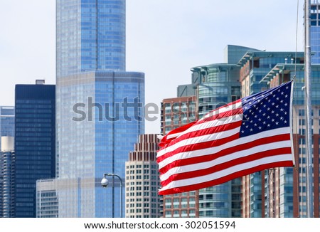 CHICAGO, USA - MAY 24, 2014: The American flag waving in front of a part of the Chicago Skyline including the Trump Tower.