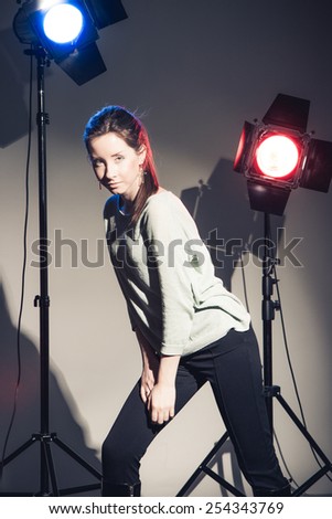 Beautiful woman posing in studio in light flashes