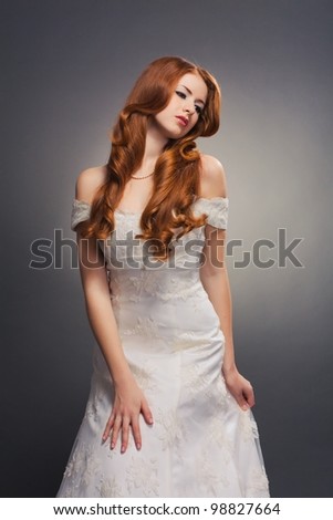 beautiful bride with curly red hair in wedding dress