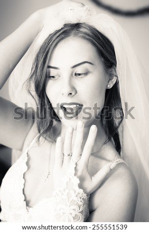 Black and white close up of showing engagement ring and happy smiling beautiful sensual young lady in white lingerie