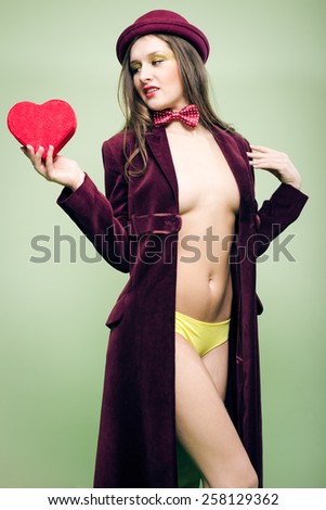 Portrait of romantic sexy beautiful young lady with red present box in the form of heart