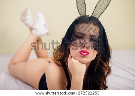 Close up portrait of sexy mysterious young pretty lady in bunny ears mask relaxing in bed