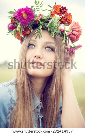 Portrait closeup of beautiful young woman wearing flower crown having fun relaxing looking up on summer green outdoors copy space background