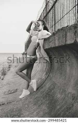 Black and white picture of sexi young female standing by floodboard