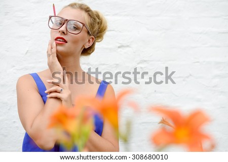 Cropped picture of amazed young woman in glasses  with orange flowers standing over white brick background copyspace