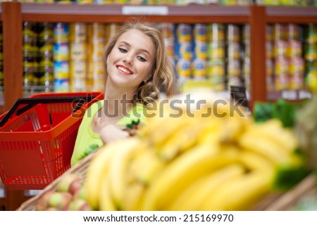 Beautiful girl in a grocery store with a basket of products