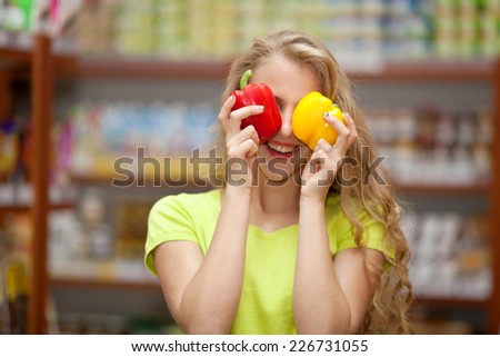 Beautiful young girl at the grocery store closed her eyes bell peppers
