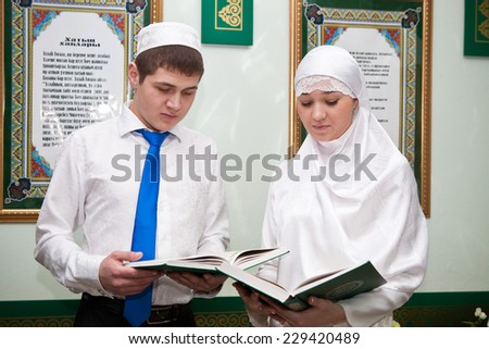 Boy and girl in national dress reading a book in the sacred mosque