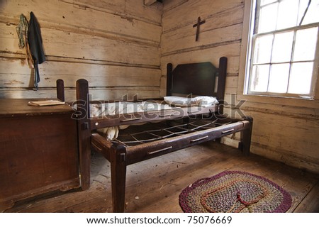Interior of a historic pioneer house with an old bed