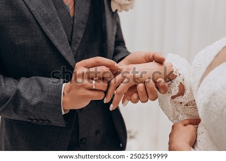 The bride wears a wedding ring to the groom at the wedding ceremony.
Hand in hand. Wedding, holiday, engagement.