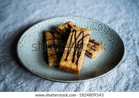 homemade proteein m?sli bars with banana and oatmeal decorated with dark chocolate as a healthy alternative without sugar. lie on a rustic plate on a wrinkled linen tablecloth Stok fotoğraf © 