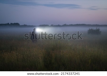 Similar – Image, Stock Photo Unrecognizable traveler with flashlight exploring foggy forest