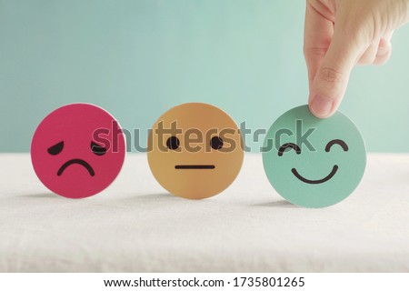 Hand choosing happy smile face paper cut, good feedback rating and positive customer review, experience, satisfaction survey ,mental health assessment, child wellness,world mental health day concept Stockfoto © 