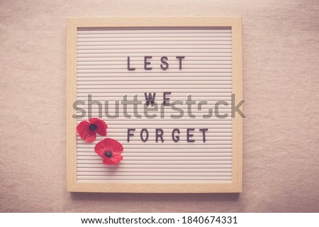 Lest We Forget and red poppy flowers on letter board Foto stock © 
