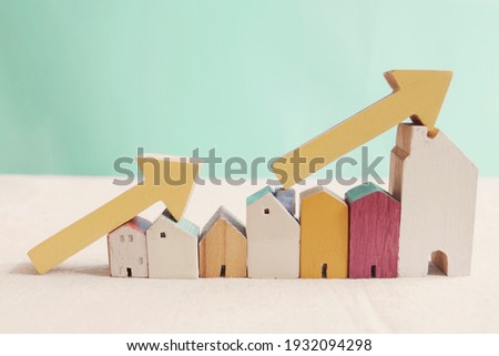 Wooden houses with yellow arrows up. housing boom, property market growing, high demand for real estate, house prices rising concept