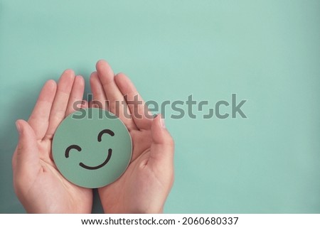 Hands holding green happy smile face , good feedback rating,positive customer review, experience, satisfaction survey ,mental health assessment, child wellness,world mental health day, Compliment Day Stock foto © 