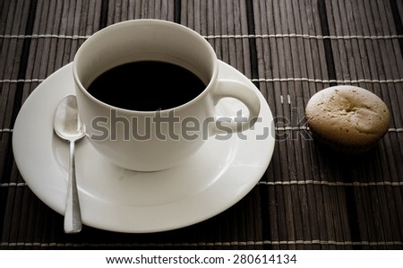 Hard light Black coffee in white cup and bakery on wooden
