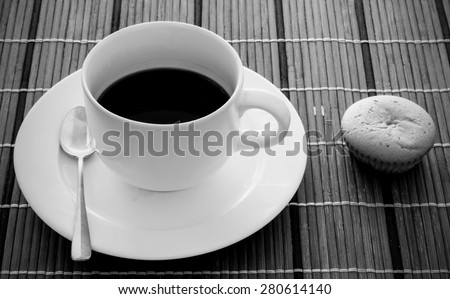 Black and white Black coffee in white cup and bakery on wooden