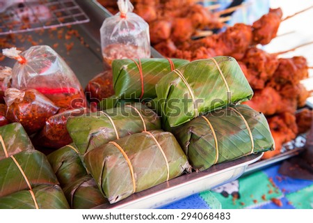 Pickled fish or pork and meat wrapped in banana leaf ,Thai style banana leaf wrapped food, made from sticky rice, pork and peanut