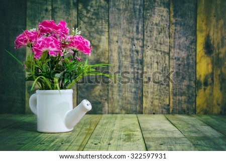 Grunge Still life of pink flower ,Plastic flower on wood
